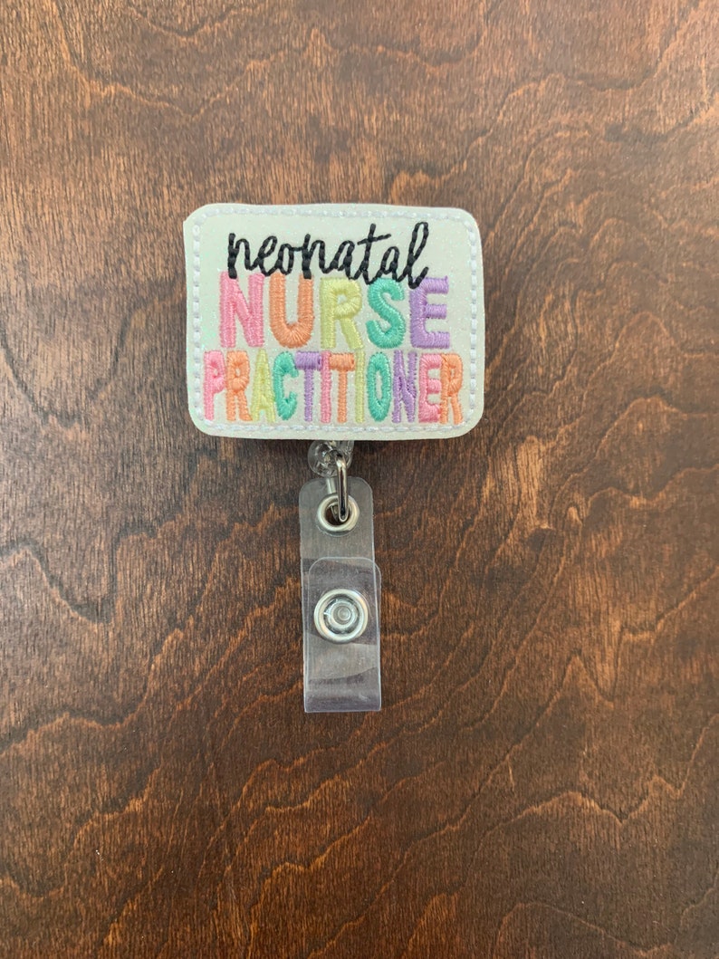 May include: White badge holder with a colorful embroidered design that reads "neonatal nurse practitioner".