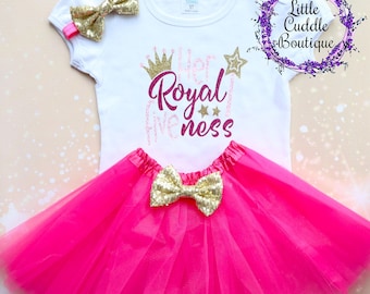 Peut inclure: Un t-shirt blanc avec un lettrage pailleté doré qui dit "Her Royal Awesomeness" avec une couronne dorée et des étoiles. Le t-shirt est associé à un tutu en tulle rose et un bandeau à nœud pailleté doré.