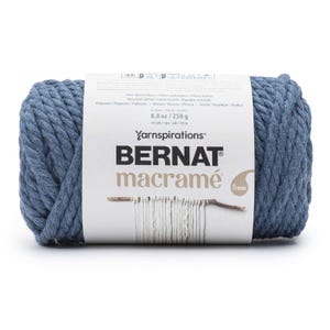 May include: A roll of Bernat macramé yarn in a dusty blue color. The label indicates the yarn is 8.8 oz (250 g) and 44 yds (40 m). The brand name and product type are prominently displayed.