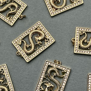 Puede incluir: Encantos de dragón de metal dorado con diamantes de imitación transparentes. Cada encanto es un marco cuadrado con un diseño de dragón en el interior. Los encantos son perfectos para la elaboración de joyas o para agregar un toque de brillo a cualquier proyecto.