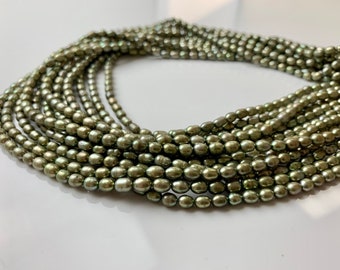 May include: A strand of green freshwater pearls, strung together in a long necklace. The pearls are oval-shaped and have a subtle iridescent sheen.