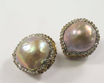 May include: A pair of pearl earrings with a gold setting and a clear rhinestone border.