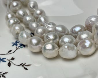 May include: A strand of white baroque pearls, each pearl is a different size and shape, with a slight iridescent sheen.
