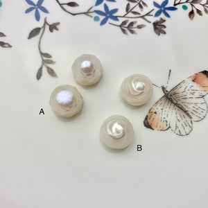 May include: Four white pearl buttons with different designs. Two buttons have a geometric design, and two buttons have a swirl design. The buttons are on a white plate with a floral pattern.
