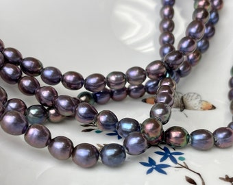 May include: A strand of dark purple, near-round freshwater pearls with a lustrous, iridescent finish. The pearls are strung together in a continuous line, displaying subtle variations in shape and deep violet to charcoal hues throughout.