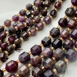 May include: A strand of faceted purple gemstone beads with gold spacers. The beads are a deep purple color with a slight shimmer.
