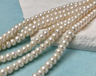 May include: Several strands of creamy white pearls are displayed against a light blue and white background. The pearls are round and evenly sized, suggesting a classic jewelry design. The image highlights the luster and color of the pearls.