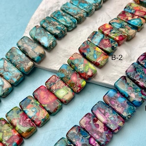 May include: Strands of rectangular gemstone beads in shades of teal, red, green, and purple. The beads have a marbled appearance, with variations in color and pattern. The image is labeled with the text "B-1", "B-2", and "B-3".