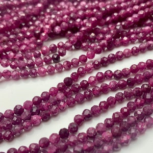 May include: A strand of faceted ruby beads, each bead is a deep pink color and has a faceted finish. The beads are strung on a clear thread and are ready to be used for jewelry making.