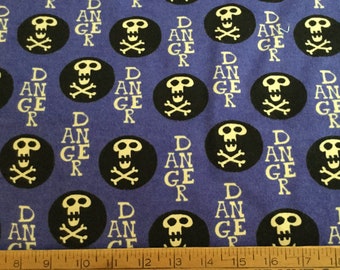 May include: Blue fabric with a repeating pattern of black circles containing a skull and crossbones, with the word "DANGER" in white. The fabric has a textured appearance.