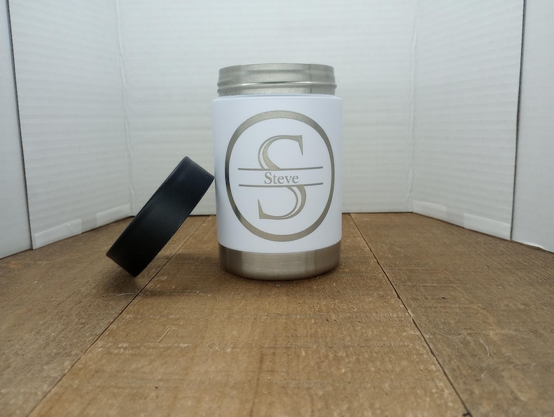 May include: White stainless steel can cooler with a black lid. The cooler features a personalised design with the letter "S" and the name "Steve" printed on it.