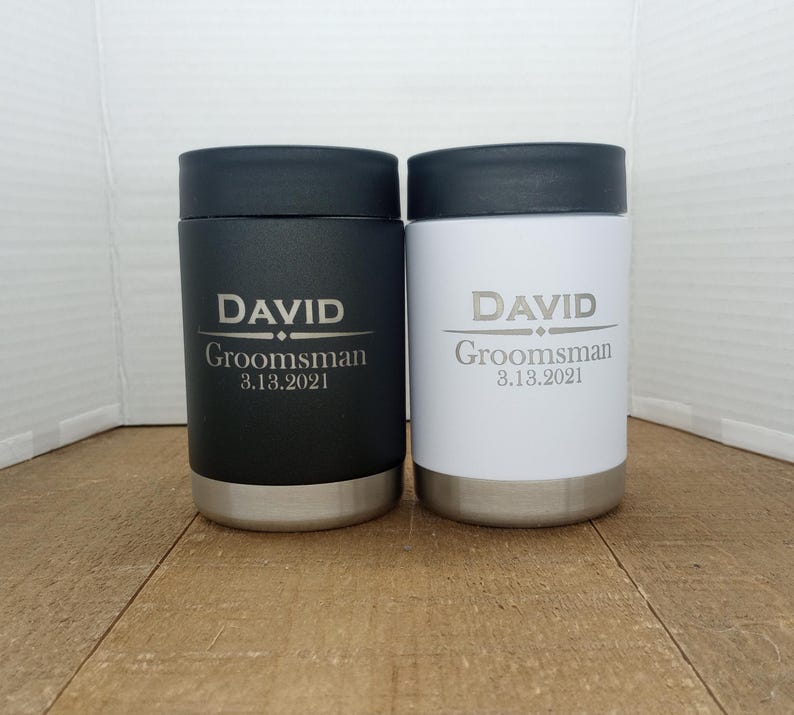 May include: Two stainless steel beverage coolers with black and white lids. The black cooler has the text "DAVID  Groomsman 3.13.2021" and the white cooler has the text "DAVID Groomsman 3.13.2021".