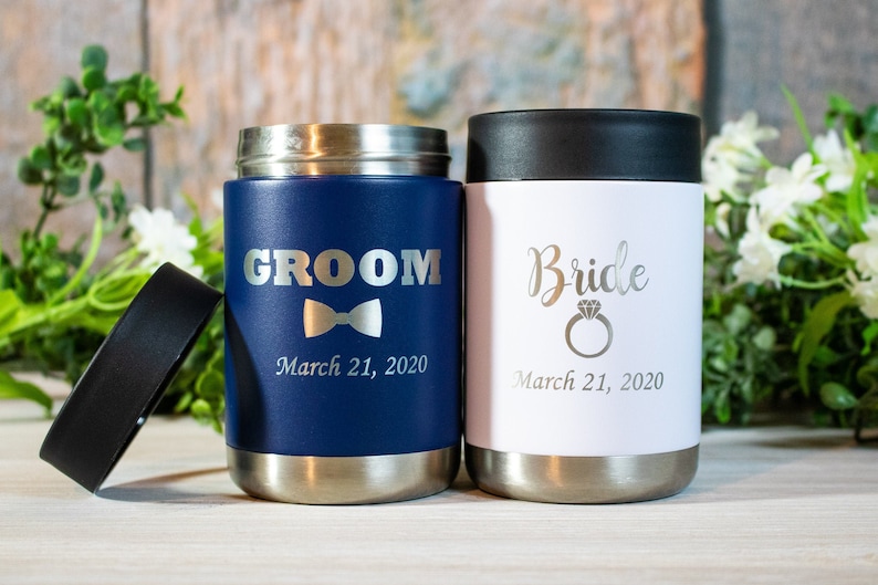 Pu&ograve; includere: Due portabevande in acciaio inossidabile con coperchi. Uno &egrave; blu navy con la parola "Groom" e un papillon, l'altro &egrave; bianco con la parola "Bride" e un anello di diamanti. Entrambi hanno la data "March 21, 2020" incisa.