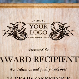 May include: A wooden plaque with an engraved design. The plaque features a company logo, the text "YOUR LOGO", "CINNNCINNATI, OHIO", "Presented To:", "AWARD RECIPIENT", "For dedication and quality work over", and "15 YEARS OF SERVICE".