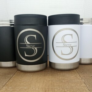 May include: Three stainless steel can coolers with a black, white and silver finish. Each cooler has a personalised design with the letter "S" and the name "Steve" engraved on it.