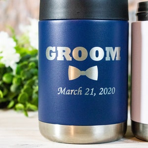 Pu&ograve; includere: Due bicchieri in acciaio inossidabile, uno blu con la parola "GROOM" e un papillon, l'altro bianco con la parola "BRIDE" e un anello. Entrambi i bicchieri hanno la data "March 21, 2020" incisa.