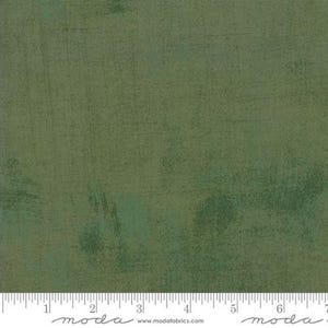 May include: Green textured fabric with a subtle mottled pattern. The fabric has a slightly rough texture and a faded, vintage look.