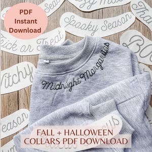Könnte beinhalten: Ein hellgraues Sweatshirt mit Rundhalsausschnitt und dem gestickten Text Midnight Margaritas in dunklem Garn entlang des Halsausschnitts. Das Kleidungsstück ist von mehreren weißen Papierausschnitten mit verschiedenen kursiven Schriftzügen umgeben.