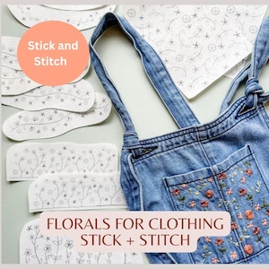 May include: A set of floral embroidery patterns for clothing, with the text "Stick and Stitch" and "FLORALS FOR CLOTHING STICK + STITCH". The patterns are printed on white paper and are shown next to a pair of denim overalls with a floral embroidery design.