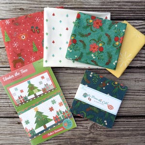 May include: A set of fabric squares with Christmas-themed prints, including a red fabric with snowflakes and reindeer, a white fabric with green trees, a green fabric with red flowers and pine branches, and a yellow fabric with white stars. The fabric squares are arranged on a wooden surface with a printed pattern booklet titled "Under the Tree" and a smaller booklet titled "In From the Cold".
