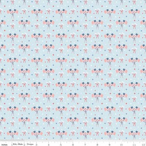 May include: Light blue fabric with a repeating pattern of American flags, red stars, and white polka dots. The flags are clustered in groups and tied with red bows. The design is suitable for patriotic-themed crafts.