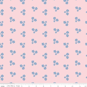 May include: A fabric with a repeating pattern of small, light blue flowers on a soft pink background. The flowers are clustered in groups of three and four, creating a delicate and feminine design. The image includes a ruler with inches.