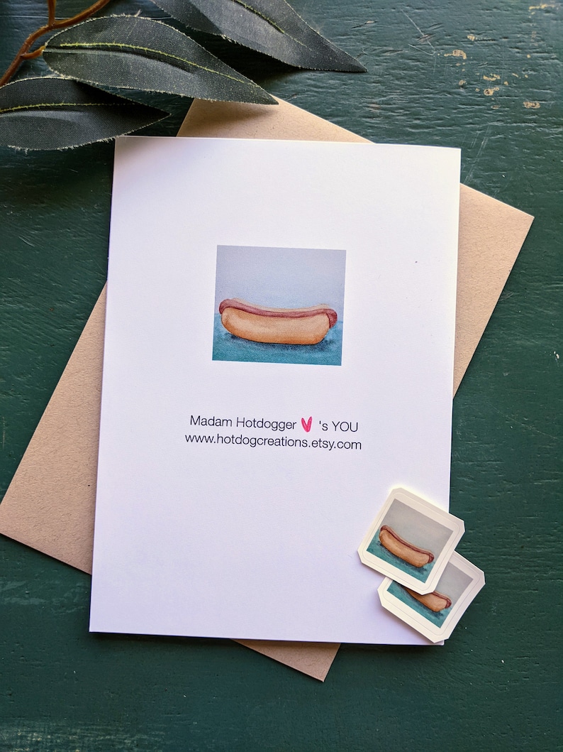 May include: A white card with a watercolor illustration of a hot dog on a blue background. The text on the card reads "Madam Hotdogger &hearts;'s YOU www.hotdogcreations.etsy.com".