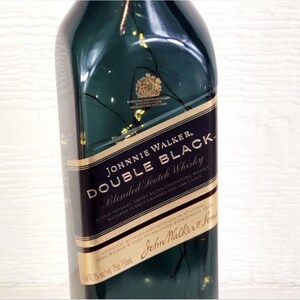 May include: A green glass bottle of Johnnie Walker Double Black Blended Scotch Whisky. The label is gold and black with the text "JOHNNIE WALKER. DOUBLE BLACK Blended Scotch Whisky A rich, intense, smoky blend containing whisky matured in deep charred old oak casks" and "DISTILLED, BLENDED AND BOTTLED IN SCOTLAND JOHN WALKER & SONS ESTABLISHED KILMARNOCK 1820 John Walker & Sons".