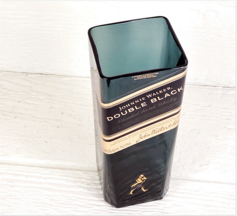 May include: A dark green glass vase with a square shape. The vase is made from a recycled Johnnie Walker Double Black Blended Scotch Whisky bottle. The label on the bottle reads "Johnnie Walker Double Black Blended Scotch Whisky".