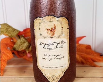 Pode incluir: Uma garrafa de vidro marrom com um rótulo que diz "Draught of the Living Death. A powerful sleeping draught. Drinker may appear dead." O rótulo também apresenta uma caveira e ossos cruzados.