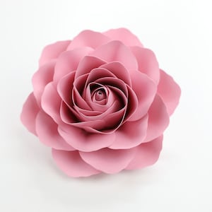 Puede incluir: Una rosa de papel grande de color rosa con m&uacute;ltiples capas de p&eacute;talos.
