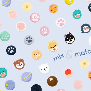 Pode incluir: Conjunto de adesivos redondos coloridos e estampados com vários desenhos, incluindo animais, plantas e símbolos. Os adesivos estão dispostos em um fundo azul claro com o texto "mix & match" no centro.