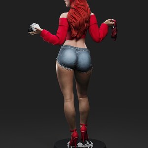 May include: A figurine of a woman with long red hair, wearing a red off-the-shoulder top, denim shorts, and red high heels. She holds a camera in one hand and a red mask in the other. The figurine stands on a black base with a white spider symbol.
