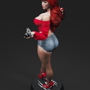 May include: A figurine of a woman with long red hair, wearing a red off-the-shoulder top, denim shorts, and red high heels. She is holding a silver camera. The figurine is standing on a black base with a white design.