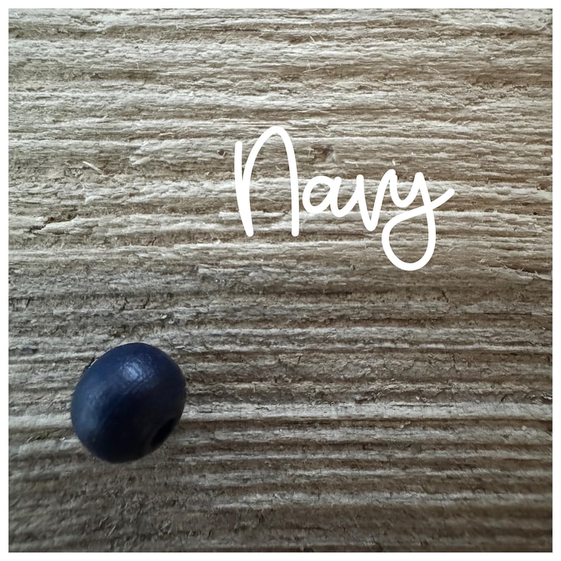 May include: A single, dark blue wooden bead on a woodgrain background. The word "Navy" is written in white above the bead.