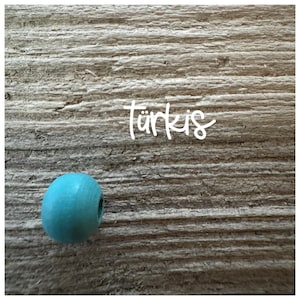 May include: A turquoise wooden bead on a woodgrain background. The word "t&uuml;rkis" is written in white above the bead.