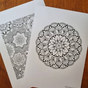 May include: Two black and white mandala designs on white paper. The design on the left is a pattern of overlapping mandalas. The design on the right is a single large mandala.