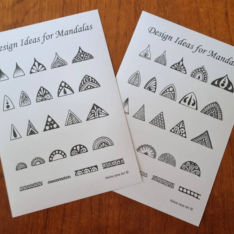 May include: Two black and white printable sheets with design ideas for mandalas. The sheets feature a variety of geometric shapes, including triangles, half circles, and borders. The text "Design Ideas for Mandalas" appears at the top of each sheet.