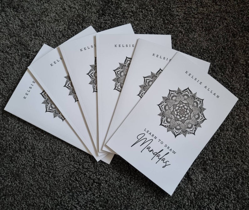 May include: A stack of six white paperbacks with black text and illustrations. The front cover features a black and white mandala design and the text "Learn to Draw Mandalas". The author's name, "Kelsie Allan", is printed on the cover.