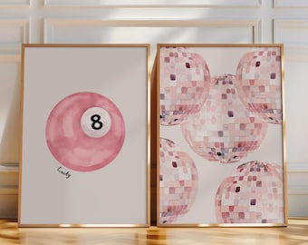 May include: Two framed art prints. One features a pink watercolor billiard ball with the number 8 and the word "Lucky". The other print displays multiple pink disco balls. Both prints have gold frames.