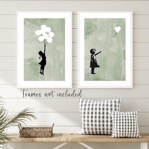 May include: Two framed prints with a green background and a black silhouette of a girl. The girl in the left print is holding balloons and the girl in the right print is reaching for a heart-shaped balloon.