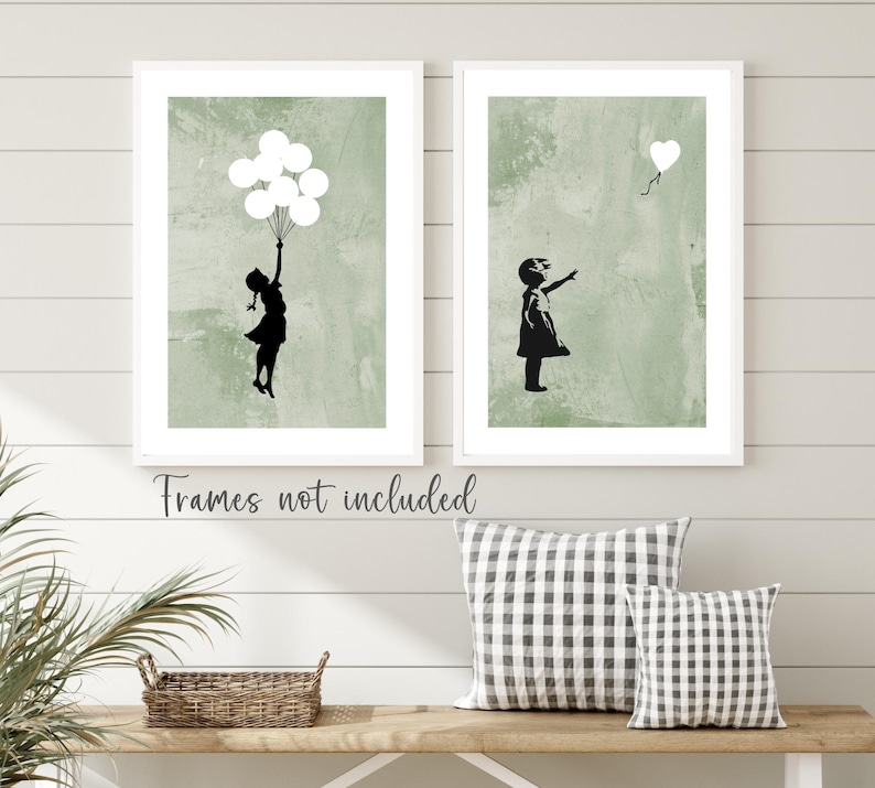 May include: Two framed prints with a green background and a black silhouette of a girl. The girl in the left print is holding balloons and the girl in the right print is reaching for a heart-shaped balloon.