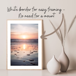 May include: A framed vertical print of a sunset over the ocean with a white border. The text above the print reads: White border for easy framing - No need for a mount. A curved arrow points from the text to the white border of the print.