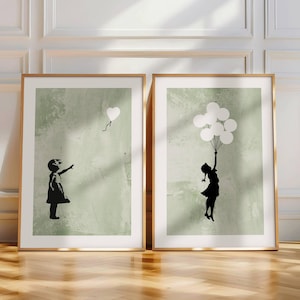 May include: Two framed prints with a green background. Each print features a silhouette of a girl. One girl is reaching for a single white heart-shaped balloon. The other girl is holding onto a bunch of white balloons.