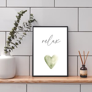 May include: A white framed print with the word "relax" in grey script and a green watercolor heart.