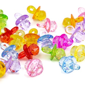 May include: Assortment of colorful plastic baby pacifier charms. The charms are in various colors, including red, yellow, green, blue, and purple.