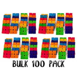 May include: A bulk pack of 100 colorful foam building blocks. The blocks are square shaped with four holes on each side. The blocks are arranged in rows of ten, with each row containing ten blocks of different colors. The colors are red, orange, yellow, green, blue, purple, and pink. The text "BULK 100 PACK" is printed below the blocks.