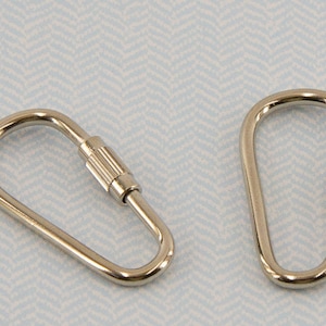 May include: Two silver keychains with a teardrop-shaped loop and a threaded swivel clasp.