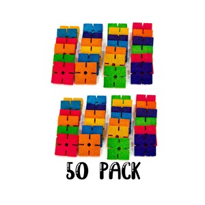 May include: A set of 50 colorful, square-shaped building blocks with a hole in the center and four slots on each side. The blocks are arranged in two rows of 25, with each row featuring a rainbow of colors. The text "50 PACK" is printed below the blocks.