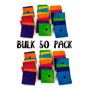May include: A bulk pack of 50 colorful wooden squares with a hole in the center. The squares are arranged in two stacks of 25, with the text "BULK 50 PACK" in black lettering between the stacks.